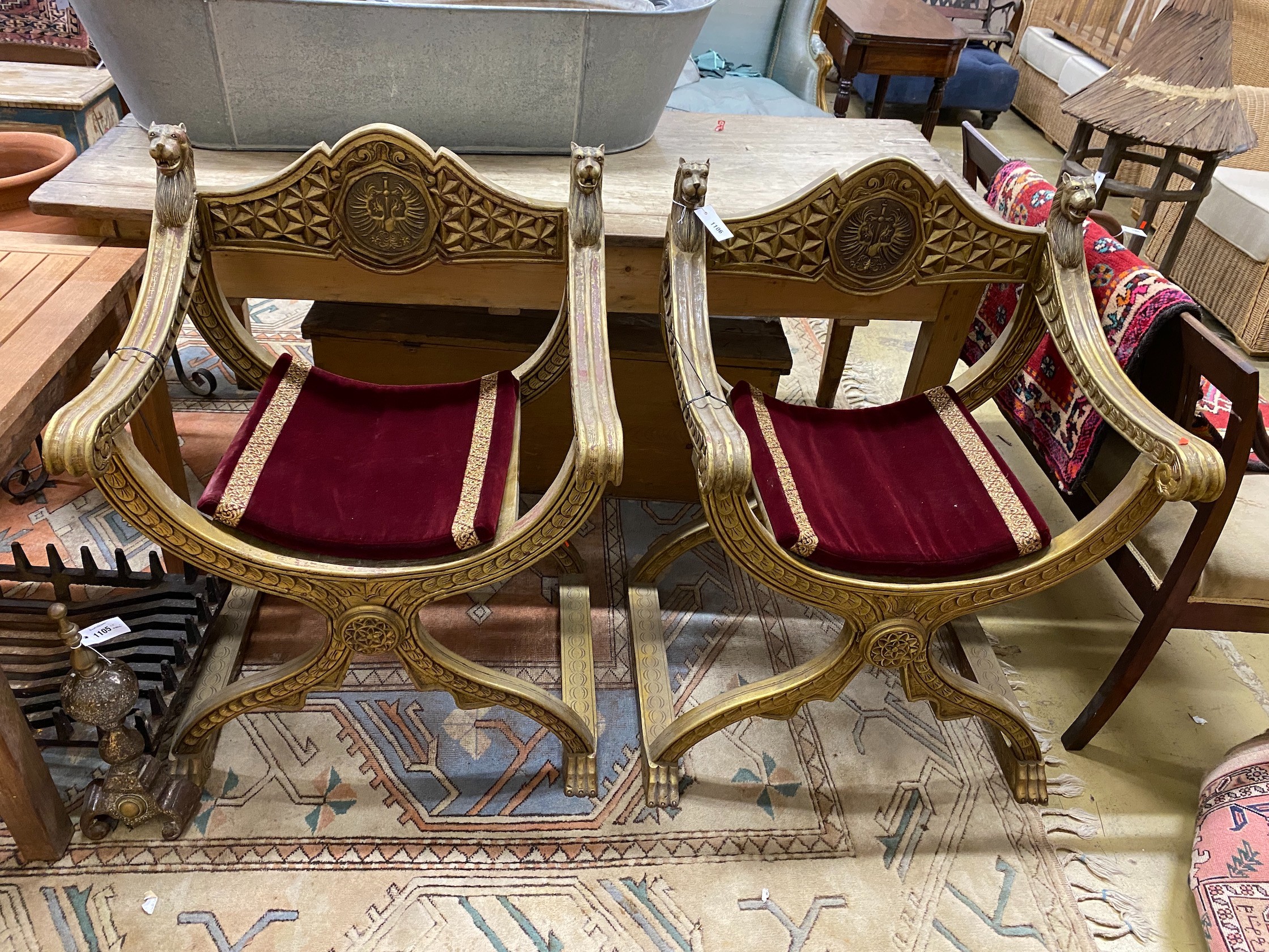 A pair of renaissance style giltwood and composition X frame elbow chairs, width 72cm, depth 51cm, height 100cm